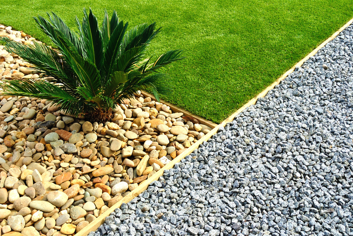 Gravel, rocks, and grass at a commercial landscaping site in Carlsbad.